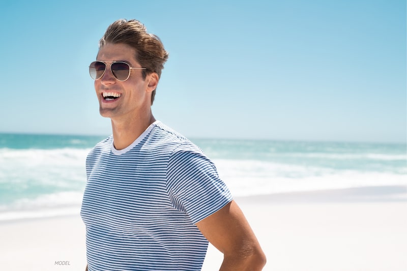 Smiling man standing on beach