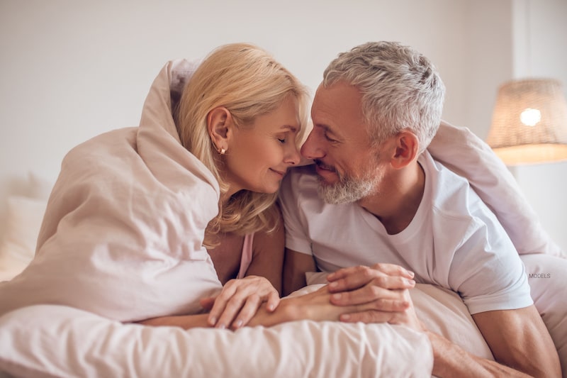 Mature couple snuggling in bed.