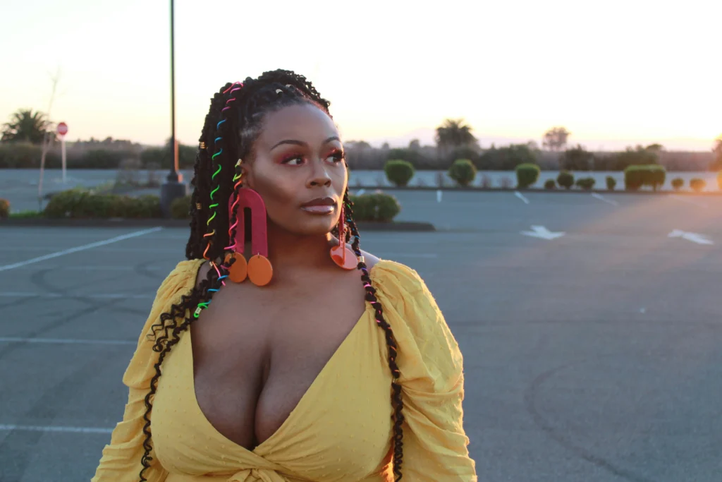 Image of a woman with large breasts in a yellow dress, illustrating what causes big breasts through genetics