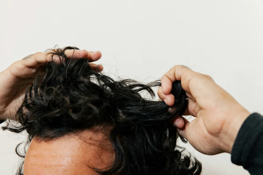 image of man examining thinning hair and receding hairline at home