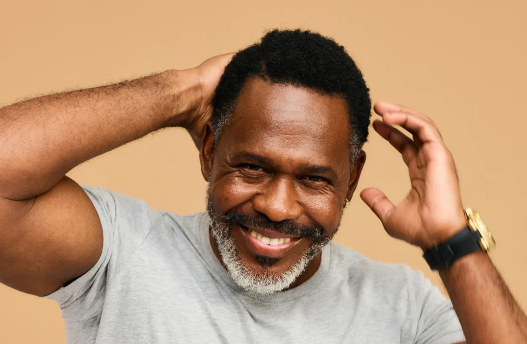 image of older man touching restored hairline after hair transplant procedure