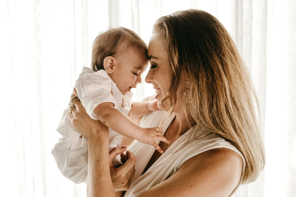 Image of a mother holding a baby smiling