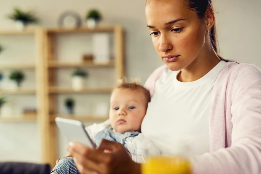 Image of a mother researching when to get tummy tuck after C-section on her phone