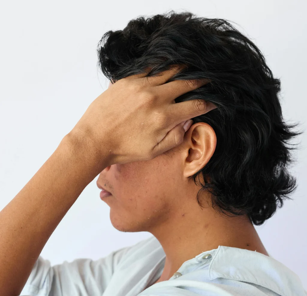 Image of a person running their hand through thick dark hair showing healthy regrowth after surgery
