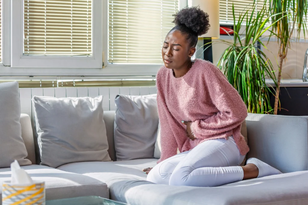 image of woman experiencing abdominal discomfort illustrating does liposuction hurt during recovery