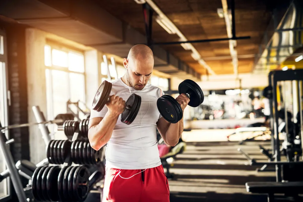 Man lifting weights at the gym, illustrating when you can exercise after a hair transplant